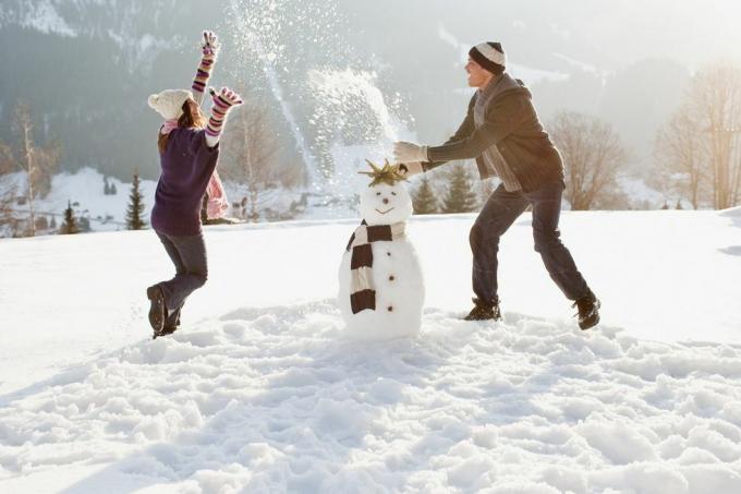زوجان يصنعان رجل ثلج ويلعبان في الثلج