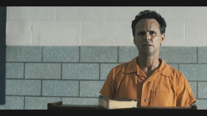 والتون جوجينز في دور بويد كرودر مرتديًا بذلة السجن البرتقالية مع خاتمة المدينة البدائية التي يبررها الكتاب المقدس