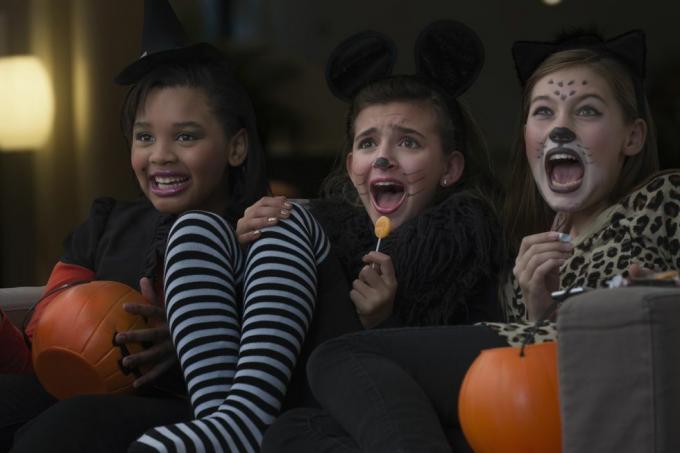 الفتيات في أزياء مشاهدة فيلم مخيف معا في عيد الهالوين