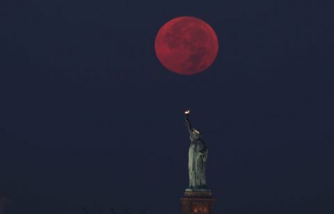 اكتمال القمر وراء تمثال الحرية في مدينة نيويورك