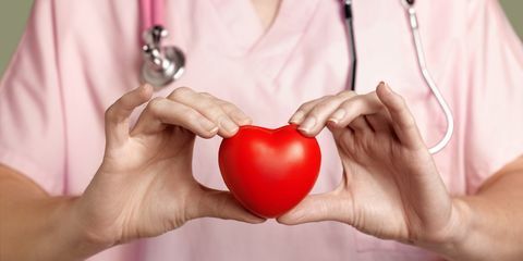طبيب القلب في الدعك الوردي يحمل القلب الأحمر