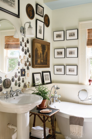 حمام مُجمَّع مع فن عتيق على الحائط وحوض استحمام بقدم مخلبية